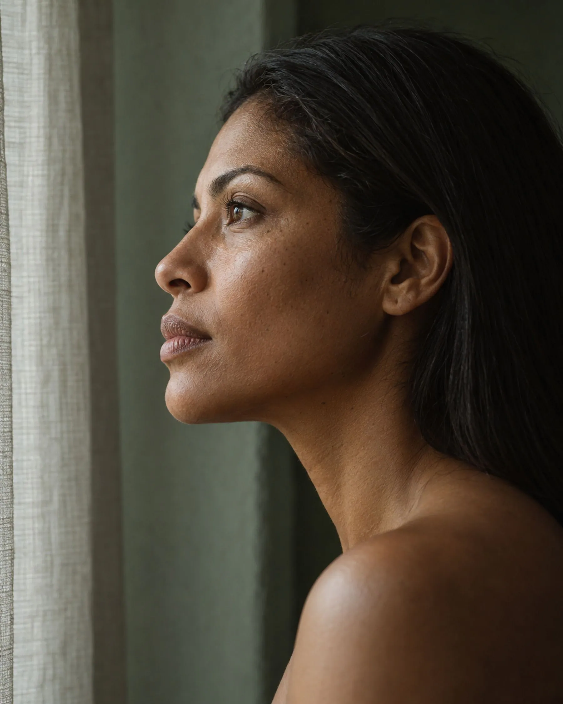 Mulher de perfil olhando para a luz da janela